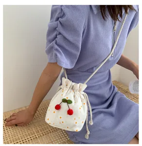 Joli petit sac seau en toile à cordon cerise florale, détail de sac bandoulière doux.