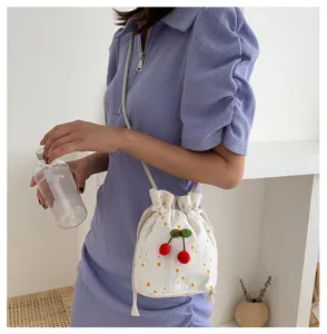 Vue rapprochée d'un petit sac seau en toile avec décor de cerises pour le style quotidien.