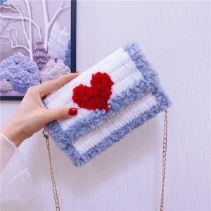 Sac bandoulière en crochet duveteux fait main avec motif de cœur rouge et chaîne dorée.