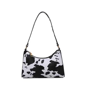 Chic black and white cow print shoulder bag for women, trendy underarm handbag daily use.
