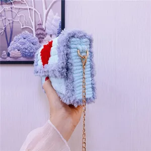 Vue détaillée du sac bandoulière au crochet duveteux, texture douce et bandoulière chaîne dorée.