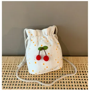 Sac seau floral blanc style ins avec cerises rouges en 3D et bandoulière tressée.