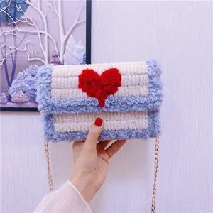 Sac bandoulière tricoté duveteux fait main avec motif cœur rouge et chaîne dorée.