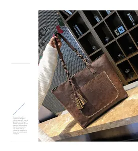 Vintage brown PU leather tote bag with braided handles and stylish tassel for women daily use.