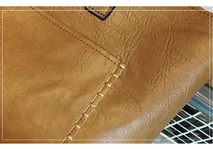 Close-up detail shot of brown PU leather women bag showing fine texture and decorative stitching craft.