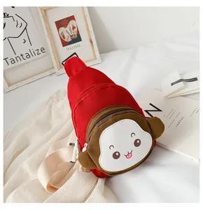 Close-up detail of the cute children's canvas sling bag featuring a playful cartoon monkey design.