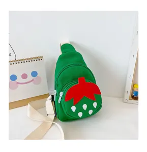 Detailed view of cute green canvas strawberry chest bag for kids, featuring vivid red leaf design.