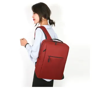 Zaino business rosso minimalista indossato da modella, ideale per il lavoro quotidiano e viaggi.