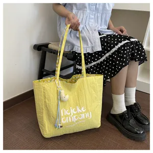 Borsa shopper in tela gialla casual con ciondolo e spallacci per il commuting quotidiano.
