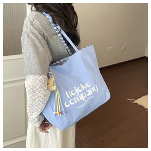 Vista dettagliata della borsa tote casual in stile coreano con ciondolo luna e tracolla.