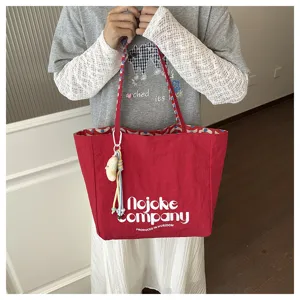 Vista dettagliata della elegante borsa tote in tela rossa con stampa per l'uso quotidiano.