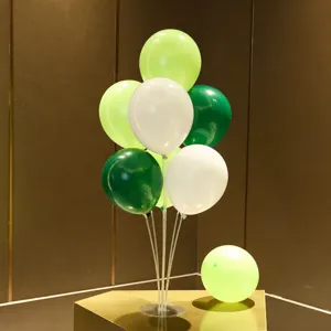 Detailed view of the balloon table stand set with green and white balloons for party decor.