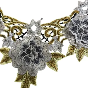 Gedetailleerde close-up van metallisch goud en zilver geborduurde kant kraag applicatie.