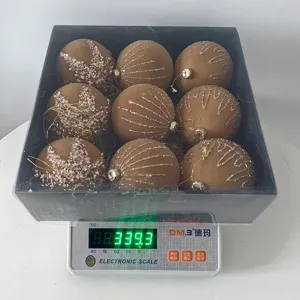Flocked Christmas baubles set of nine in black gift box with glitter patterns shown on digital scale.