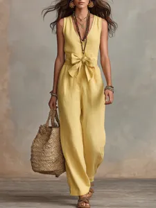 Détail de combi en lin jaune, col V sans manches avec nœud à la taille et jambe large.