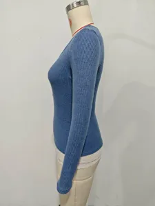 Detail view of the blue ribbed long sleeve knit top with lace trim and slim fit design.