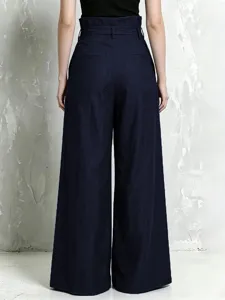 Back view detail of high-waisted linen blend wide leg trousers featuring paperbag waist and pleats.