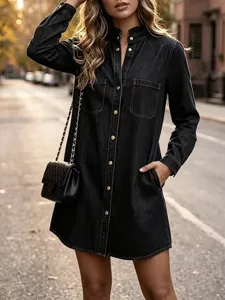 Dark denim shirt dress detail, featuring a ruffle stand collar, snap buttons, and side pockets.