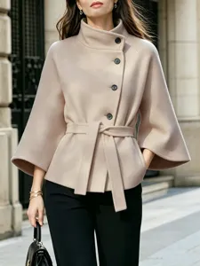 Solid color long-sleeve belted woolen coat with high collar and chic asymmetric button design.