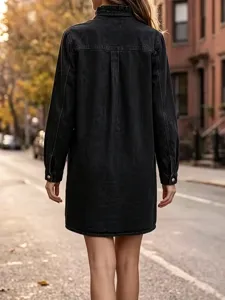 Detailed back view of casual black denim shirt dress with ruffled mock neck outdoors.