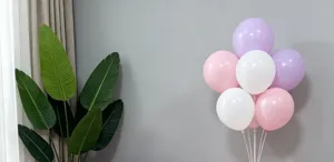 Detail view of colourful latex balloons in pink, white, and purple for party decoration.