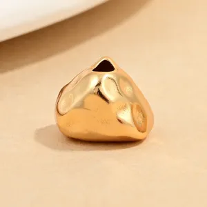 Close-up detail of irregular gold hammered triangle spacer bead for jewelry DIY crafting.