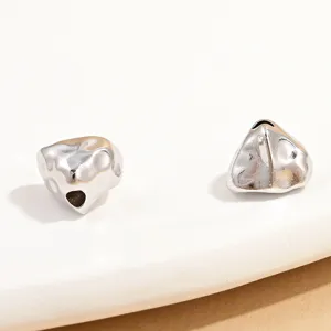 Detail shot of irregular silver triangle spacer beads for DIY jewelry making and crafting.