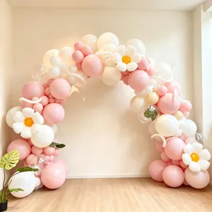 Detailed view of pink and white balloon arch with cute daisy flower balloons for party decor.