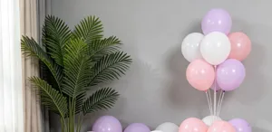 Pastel latex balloons bouquet set with artificial palm plant decor for party decoration.