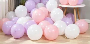 Detailed close-up view of colorful latex balloons in pink, white and purple for party decor.