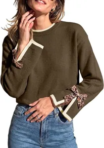 Detailed view of women's round neck sweater featuring contrast ribbed cuffs and cute leopard bows.