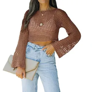 Vista detallada de un elegante crop top de punto marrón calado de manga larga con vaqueros.