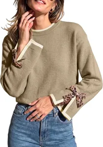 Close-up of women's knit sweater featuring contrast ribbed cuffs and stylish leopard bows.