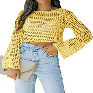 Vista detallada del crop top de punto calado amarillo con mangas largas y cuello redondo.