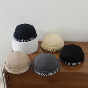Detailansicht der Retro Dockworker Mütze mit Buchstabenstickerei in bunten Farben.