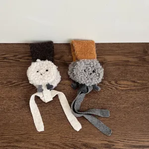 Detailweergave van pluizige lamsvacht kinderen oorkleppen met schattige lange bungelende linten.