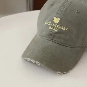 Primo piano dettagliato del berretto da baseball per bambini lavato vintage con ricamo d'orso.