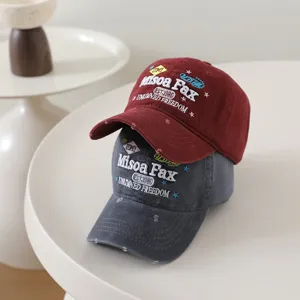 Close-up detail of retro embroidered letter baseball hat with distressed brim and soft crown design.
