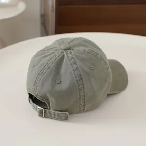 Primo piano del cappellino da baseball per bambini verde lavato con fibbia in metallo.
