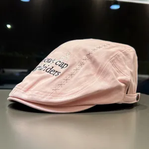 Children's pink beret cap with stylish letter embroidery and stitching details for kids.