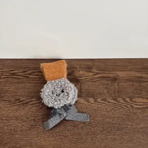 Detailopname van kinder winter pluche oorkleppen met lange banden in grijs en oranje.