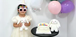 Birthday party decoration props set with cute balloons, cake and plush bunny toys for kids.