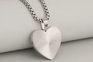 Vista detallada de un elegante collar con colgante de corazón cepillado en acero inoxidable.