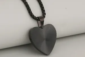 Primer plano detallado de la fina textura metálica del colgante de corazón negro.