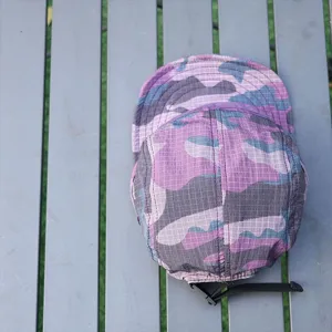 Detail view of the purple camo 5-panel camp cap, showing quick-dry grid fabric and brim.