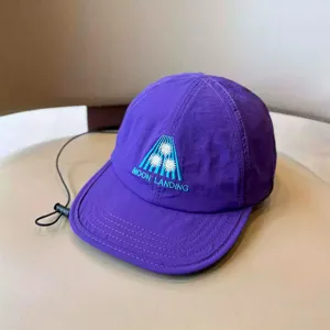 Purple children quick drying baseball cap detail showing moon landing embroidery design.