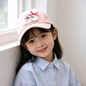 Cute kids pink baseball cap with sweet bow and lace patch, perfect for outdoor summer sun.
