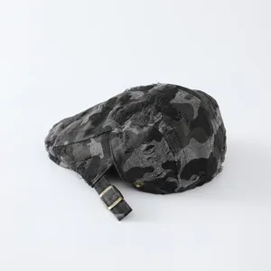 Détail de casquette plate camouflage usée, tissu texturé vintage avec boucle de sangle réglable.