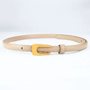 Cinturón fino de mujer minimalista de cuero con hebilla dorada en U, fondo blanco.