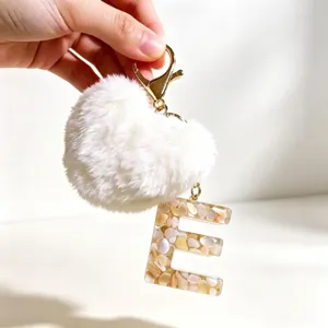 Beige Harz Buchstabe E Schlüsselanhänger mit weißem flauschigen Herz Pompon für Taschen